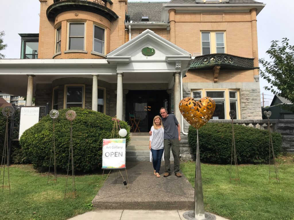 Paula Crawford with artist Paul Knoblauch in front of her gallery.